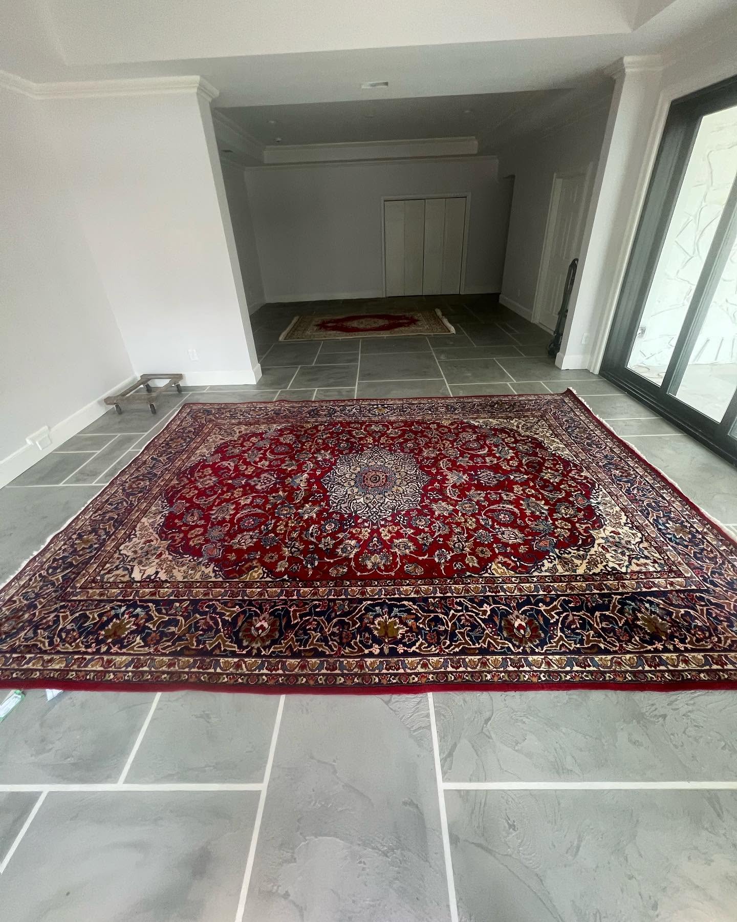 Grey stained concrete tile floor with decorative rug
